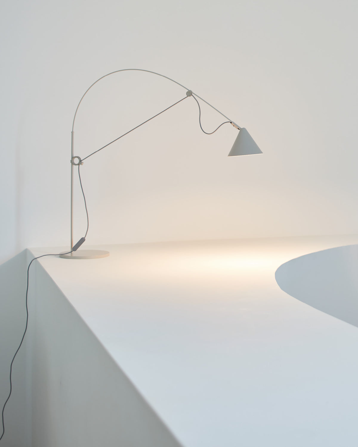Midgard AYNO S adjustable table lamp in silk grey illuminating a table in a modern interior