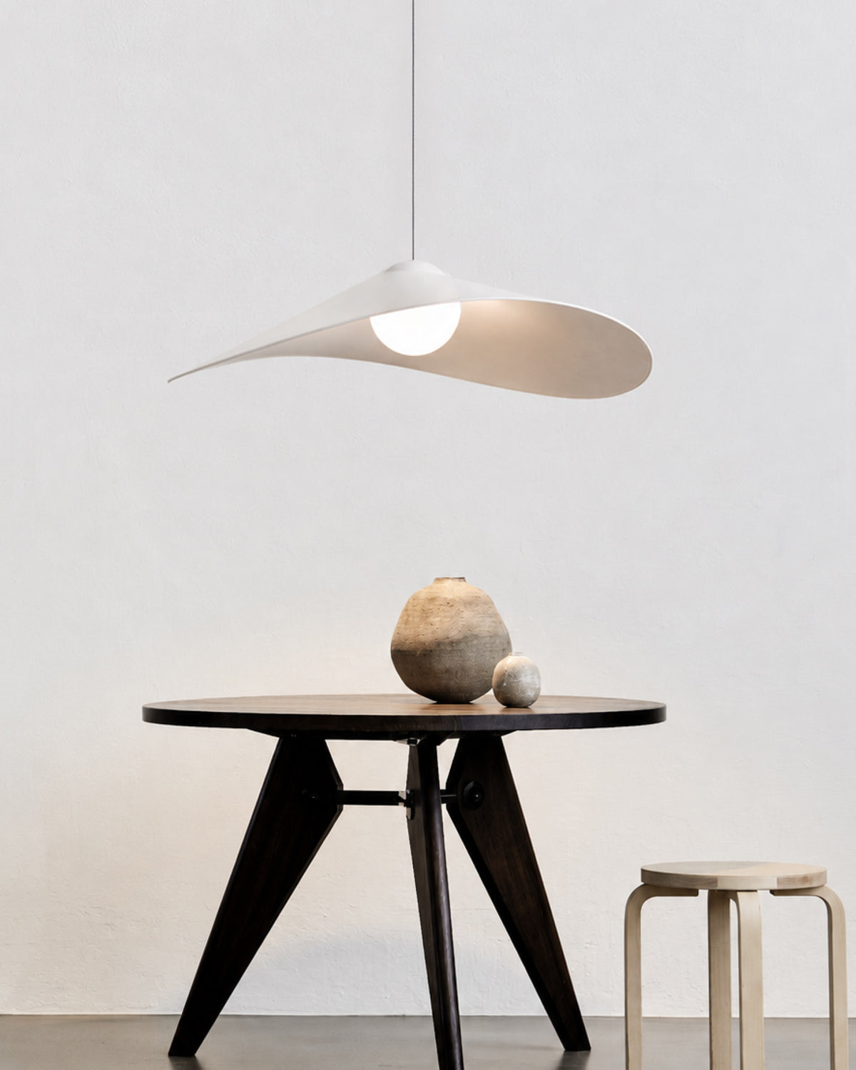 LOJA pendant lamp by Sebastian Herkner for Midgard, with a curved paper shade creating an interplay of direct and indirect light.