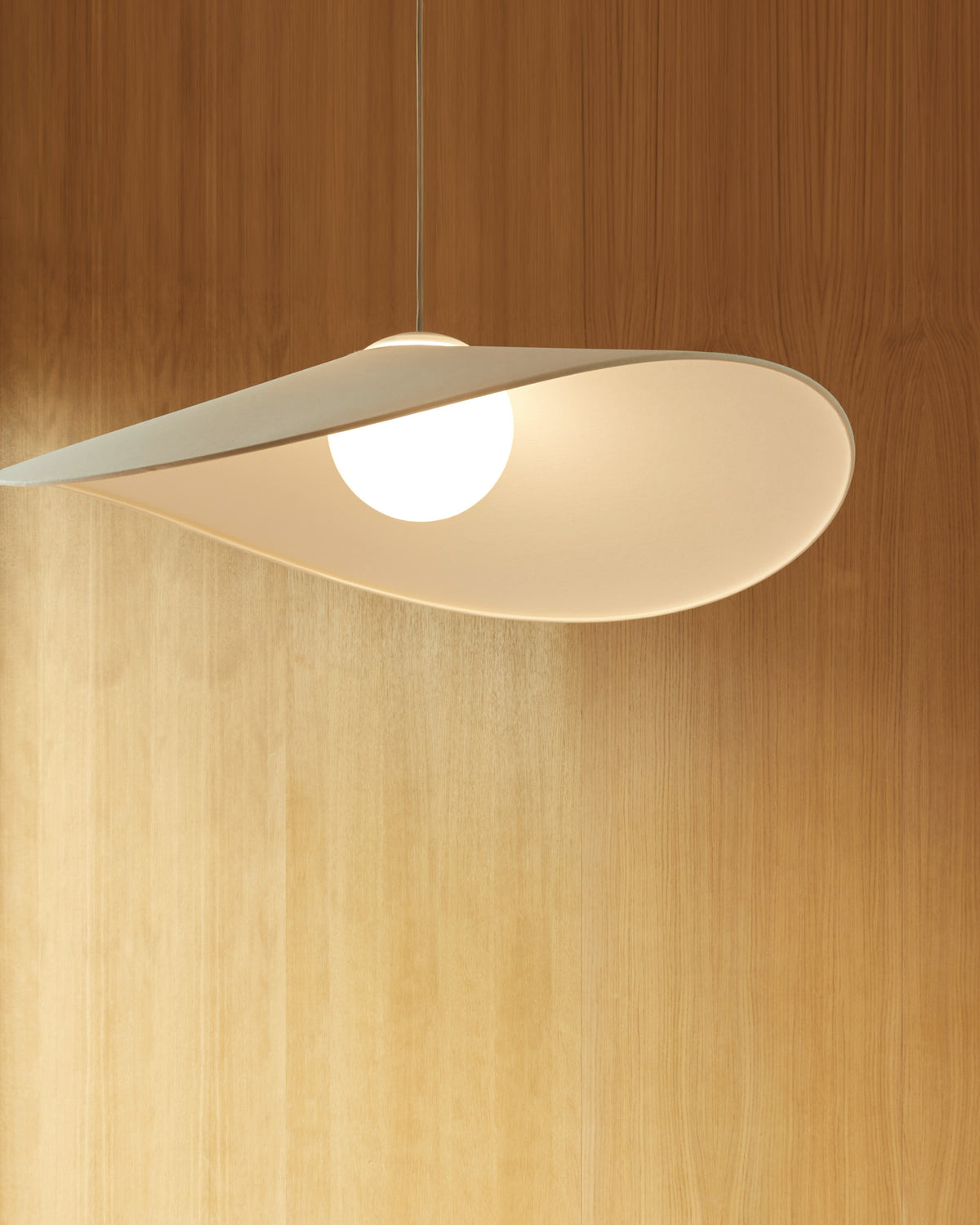 Close-up of the LOJA pendant lamp by Sebastian Herkner for Midgard, showing the illuminated paper shade and Tunable White LED.