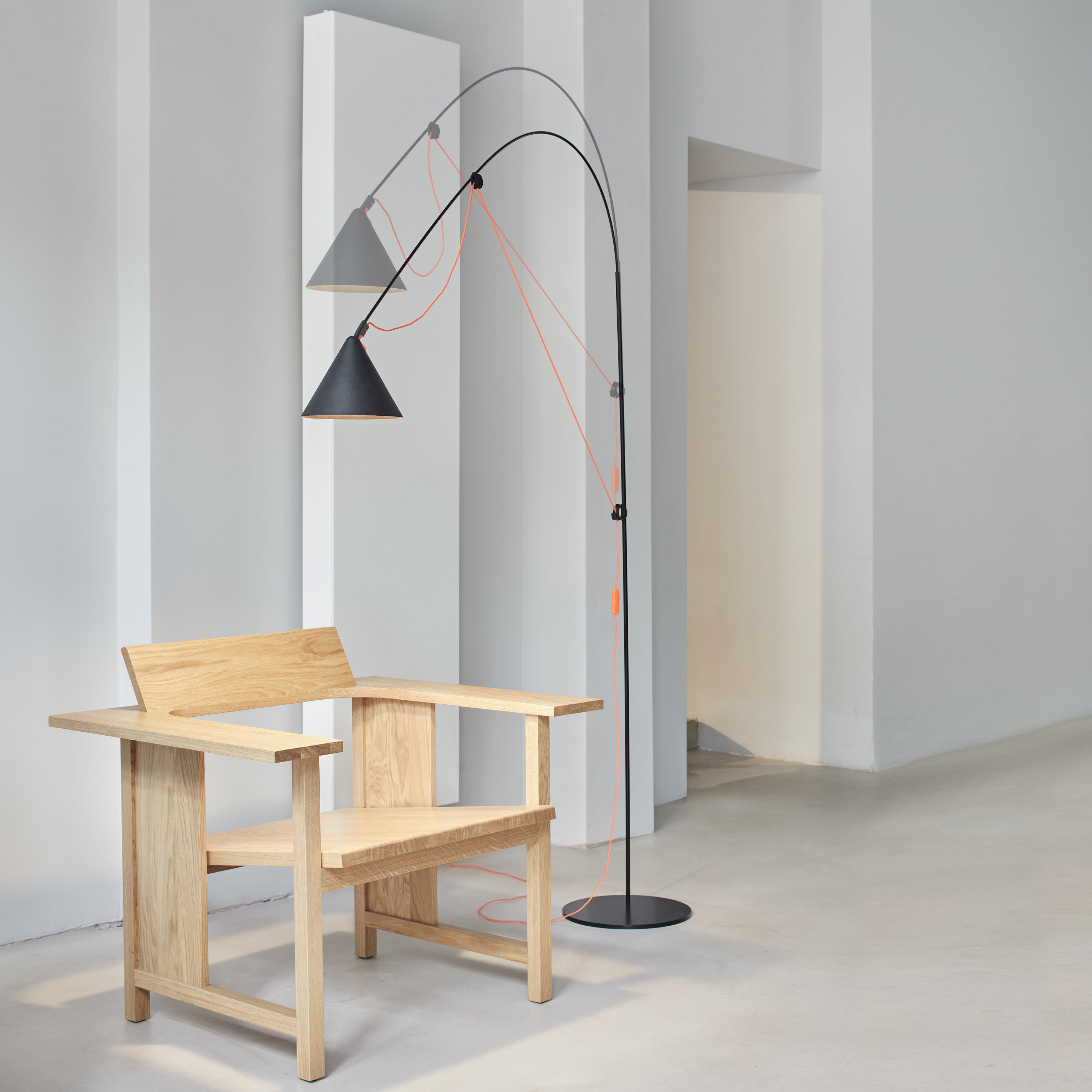 AYNO L floor lamp, contemporary statement floor lamp in matte black, extending over a lounge chair