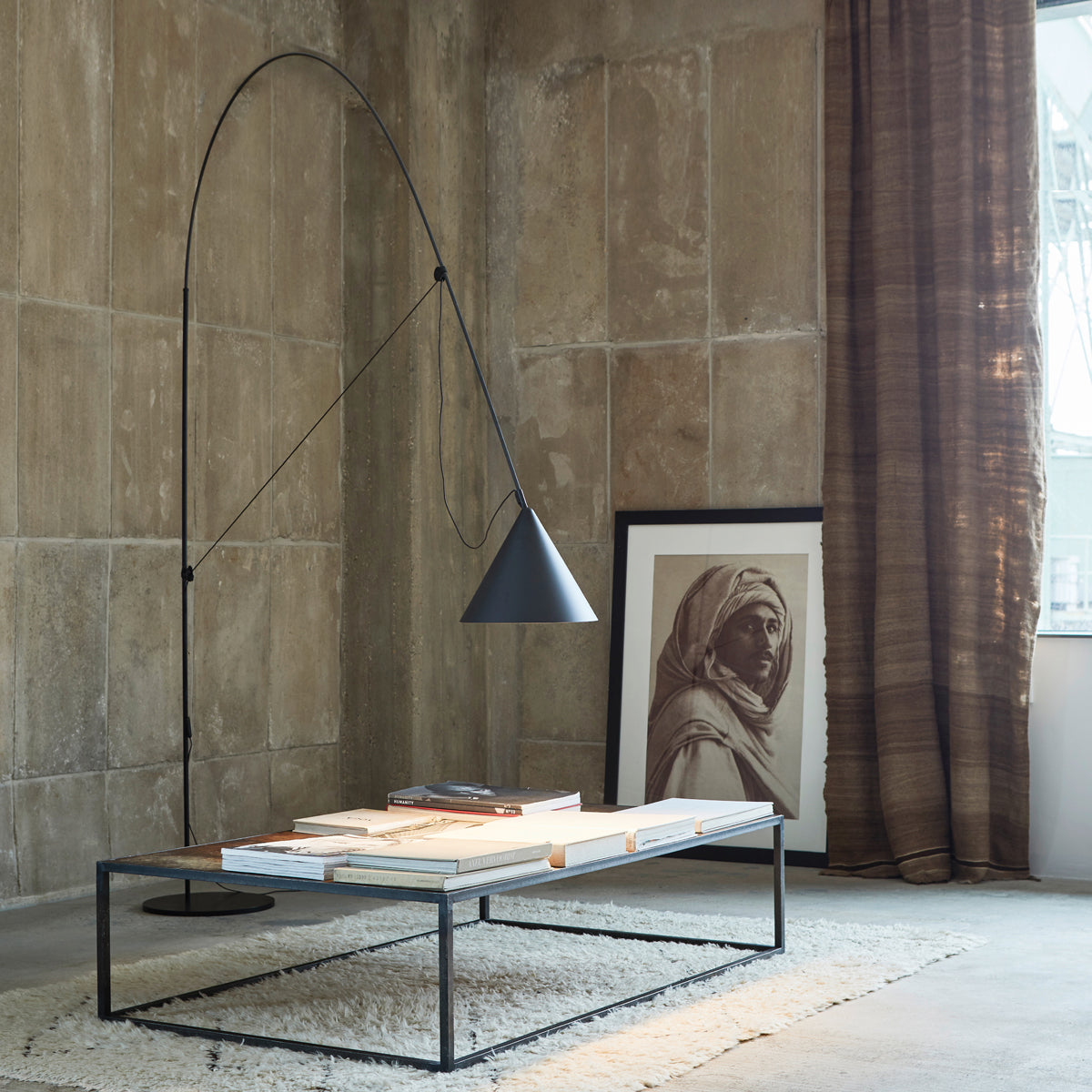 Modern black floor lamp Ayno by Stefan Diez with tension cord design, styled with a couch table