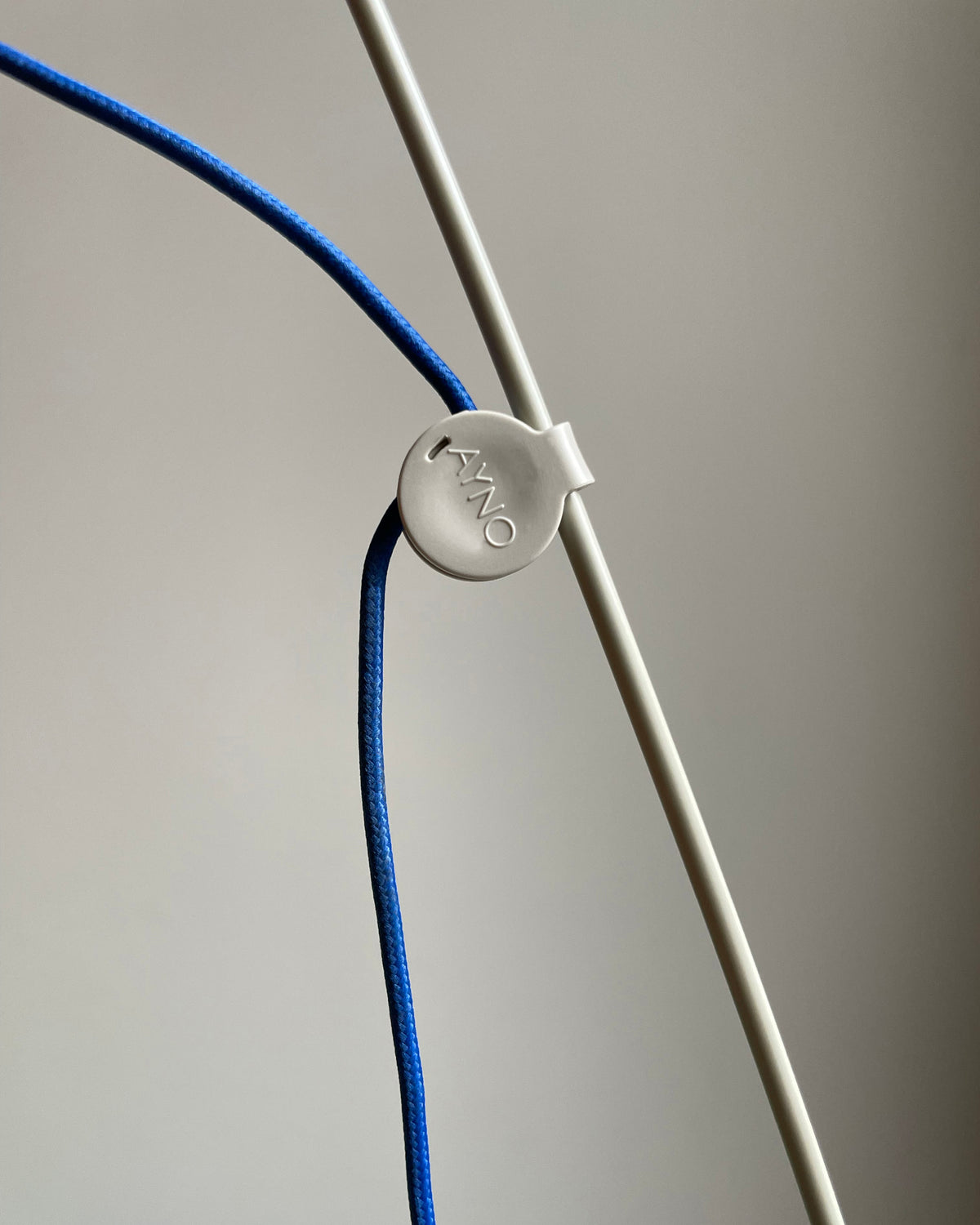 Patented adjustment ring of the Midgard AYNO XL adjustable wall lamp in silk grey with ultramarine blue textile cable