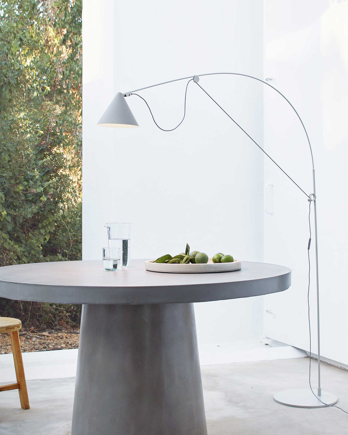 Midgard AYNO L adjustable floor lamp in silk grey beside a dining table