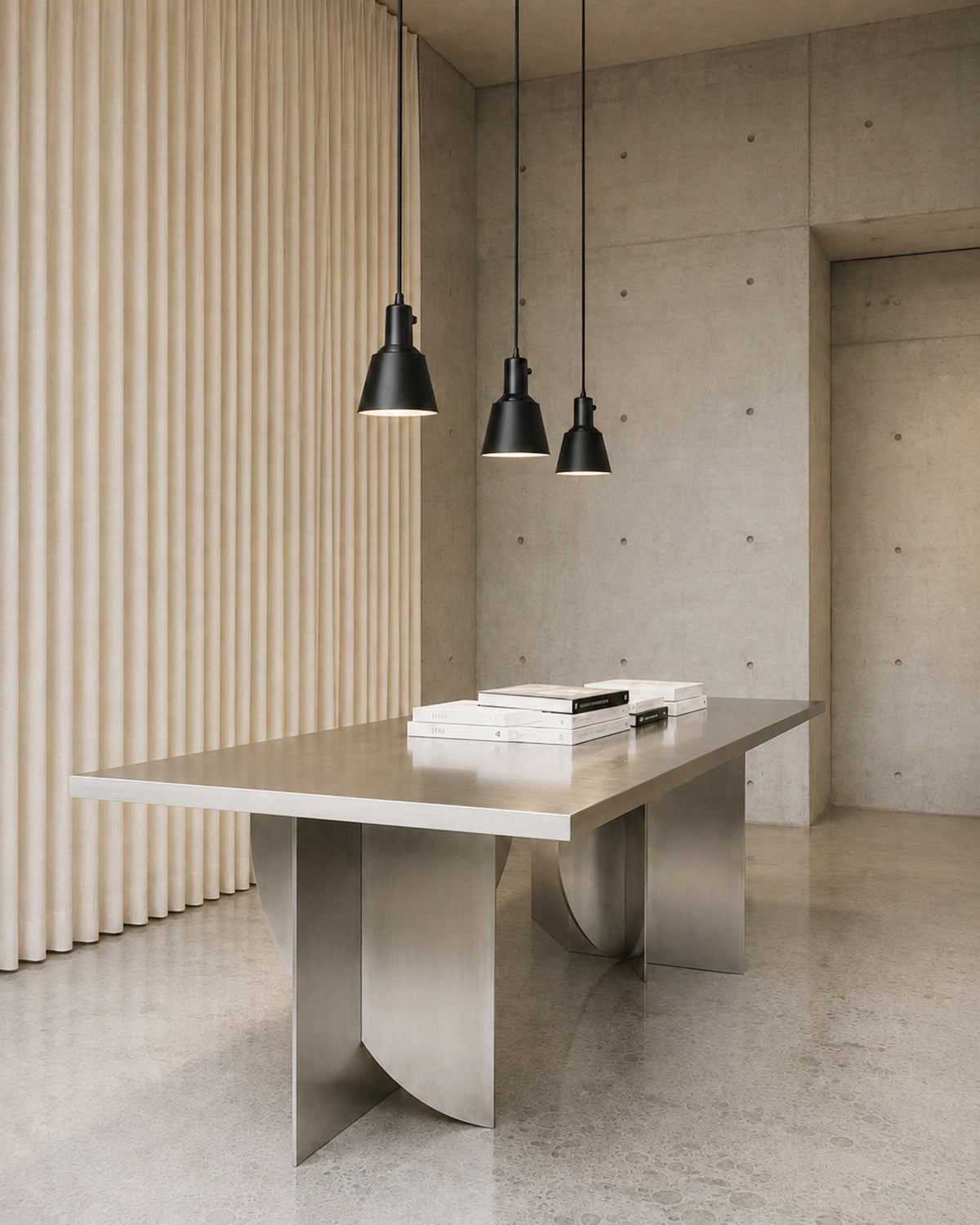 Three Midgard K831 pendant lamps in powder-coated black above a dining table providing directional light.
