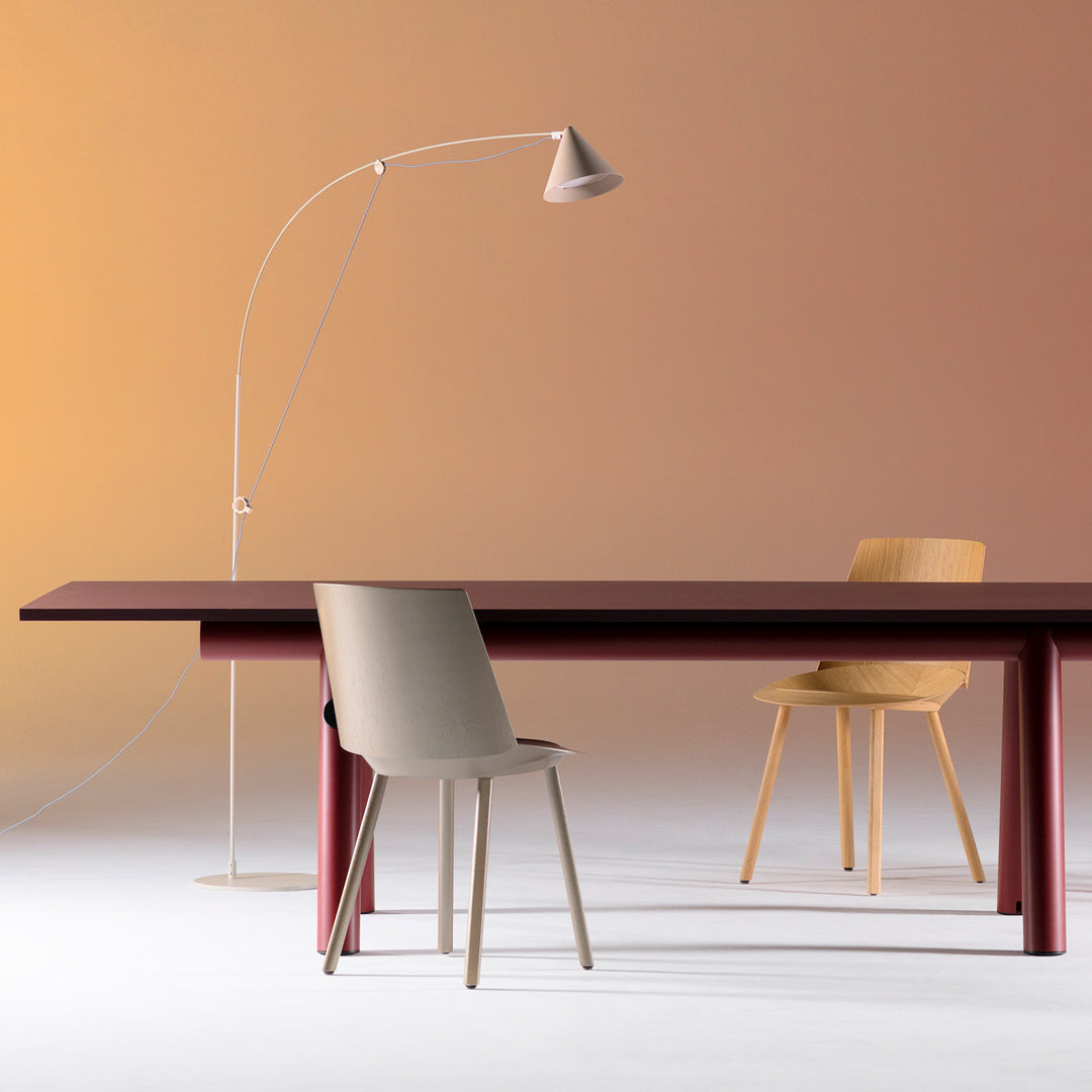 Sculptural floor lamp with a long arched arm in silk grey, perfect for statement lighting, in a setting of Stefan Diez designs with HAY and e15