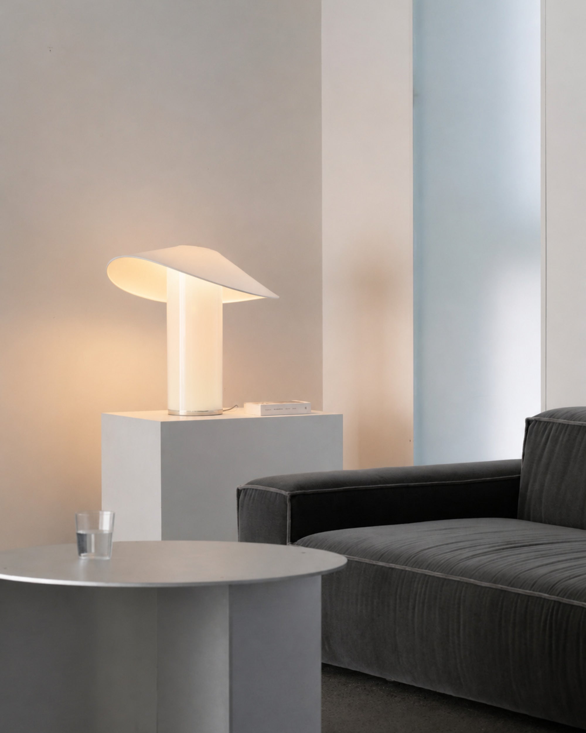 LOJA table lamp by Sebastian Herkner for Midgard in a living interior, combining direct and indirect light.