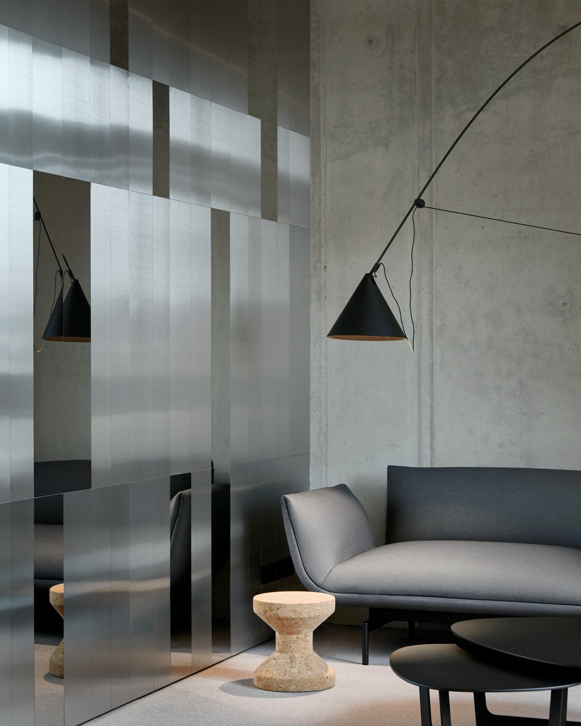 Midgard AYNO XL adjustable floor lamp in black beside a sofa in a modern living interior