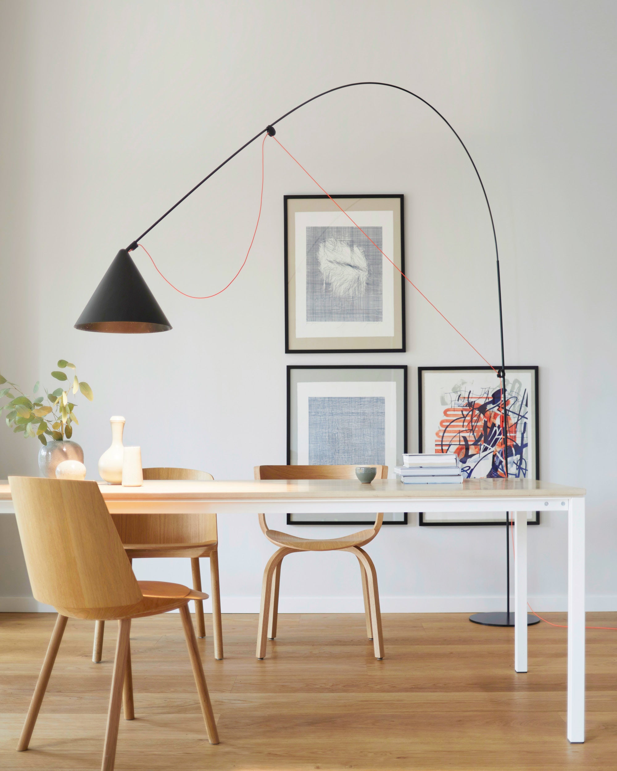 Midgard AYNO XL adjustable floor lamp in black illuminating a dining table in a modern interior