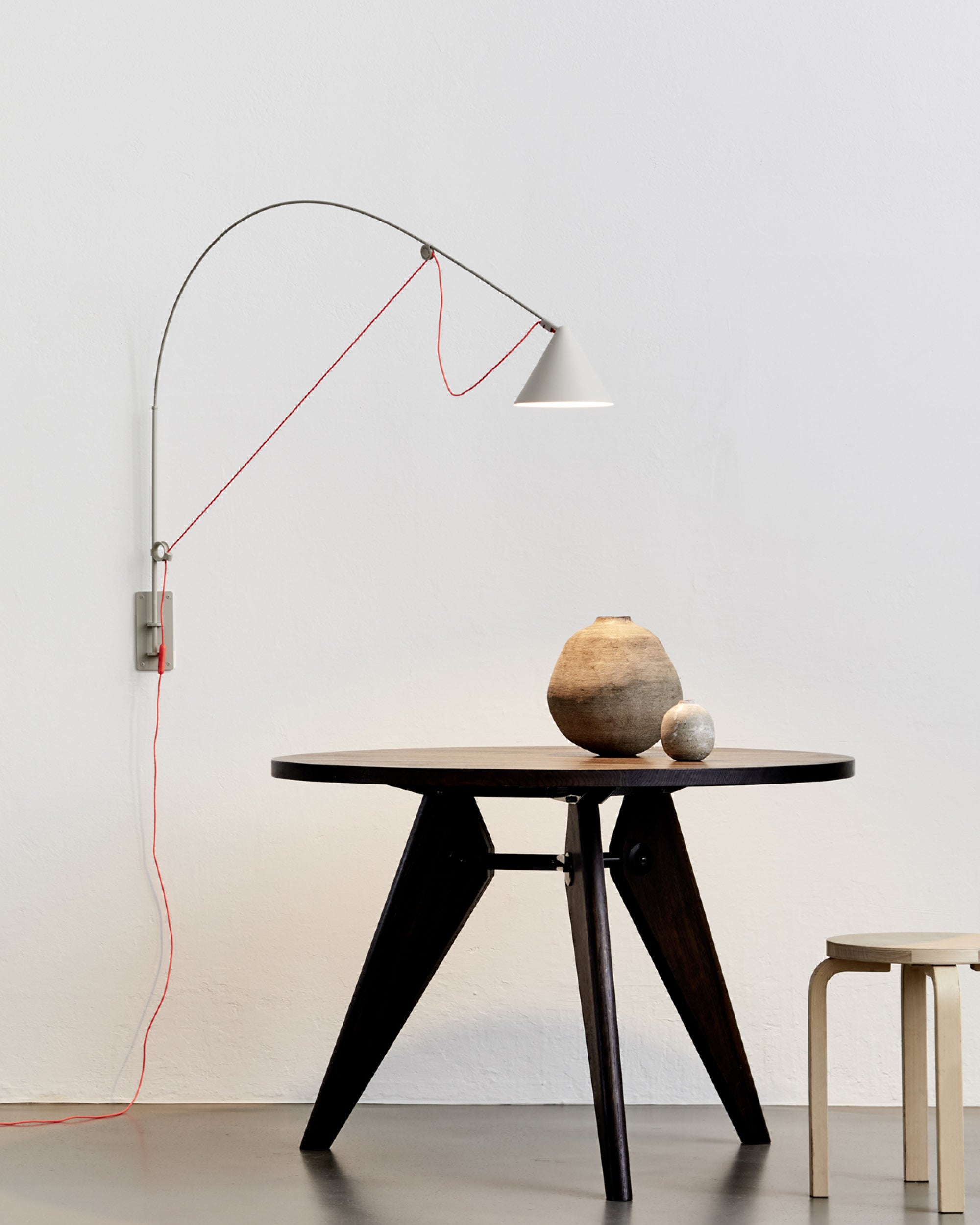 Midgard AYNO L adjustable wall lamp in silk grey illuminating a dining table in a modern interior