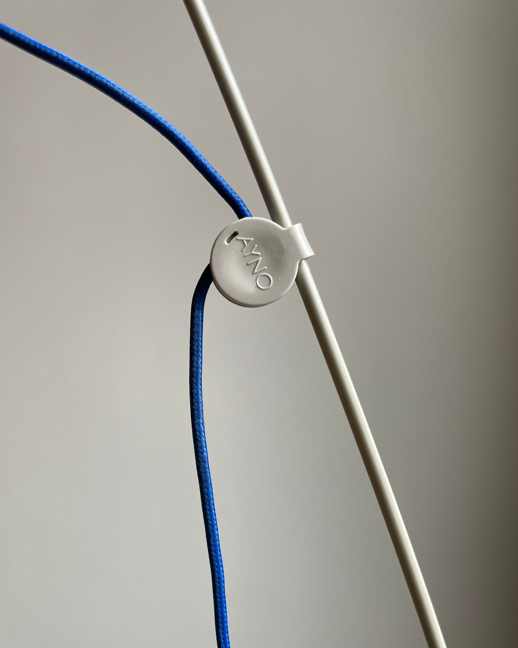 Patented adjustment ring of the Midgard AYNO XL adjustable wall lamp in silk grey with ultramarine blue textile cable