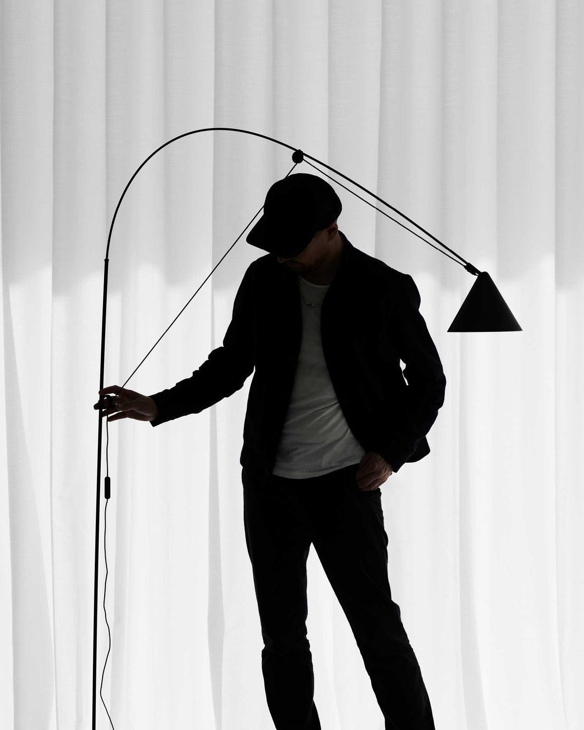 Midgard AYNO L adjustable floor lamp in black designed by Stefan Diez, demonstrating its flexible reach