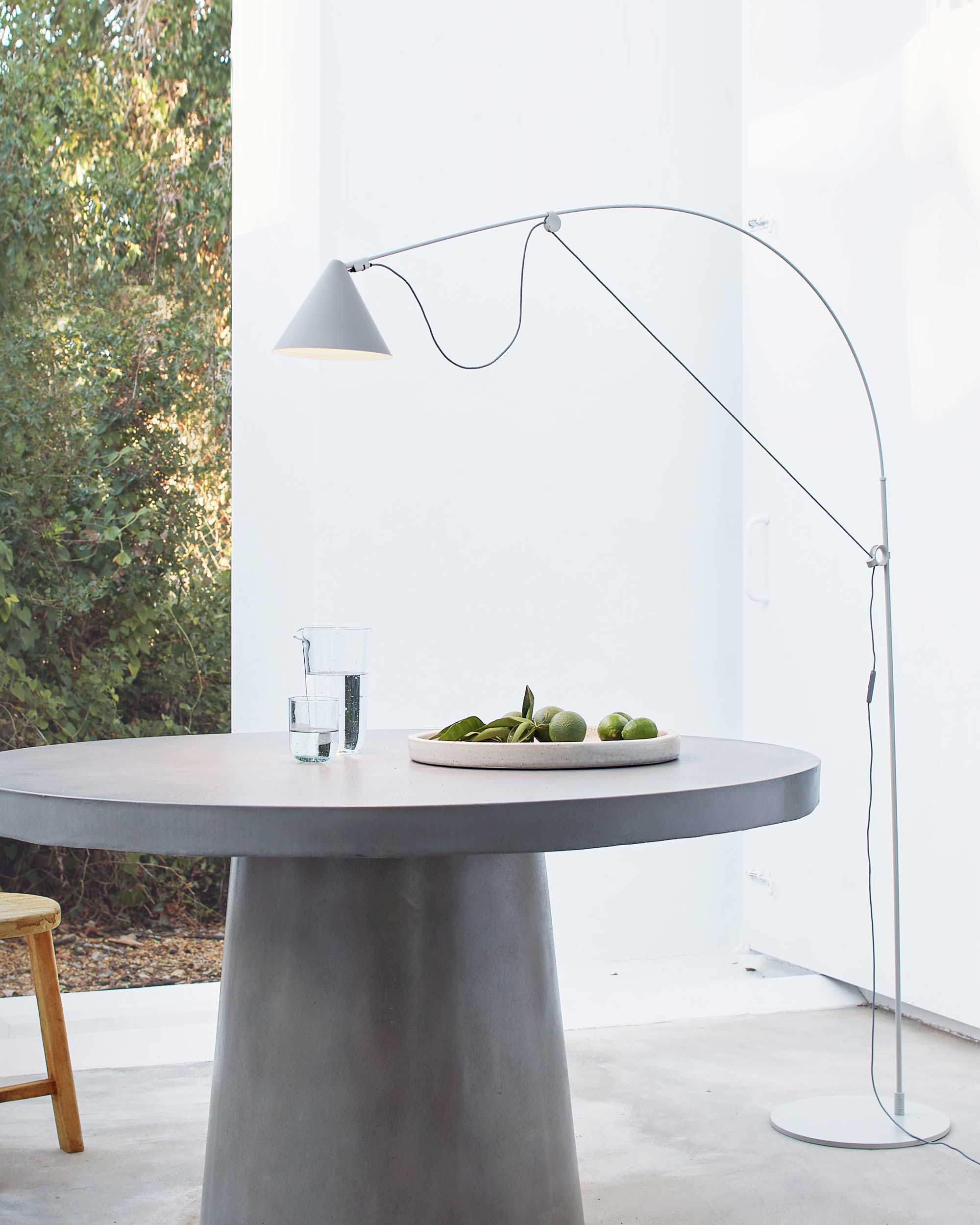 Midgard AYNO L adjustable floor lamp in silk grey beside a dining table