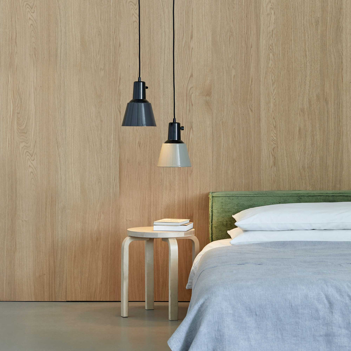 Midgard K831 pendant lamp suspended beside a bed with an integrated rotary switch and adjustable lampshade for convenient bedside lighting.