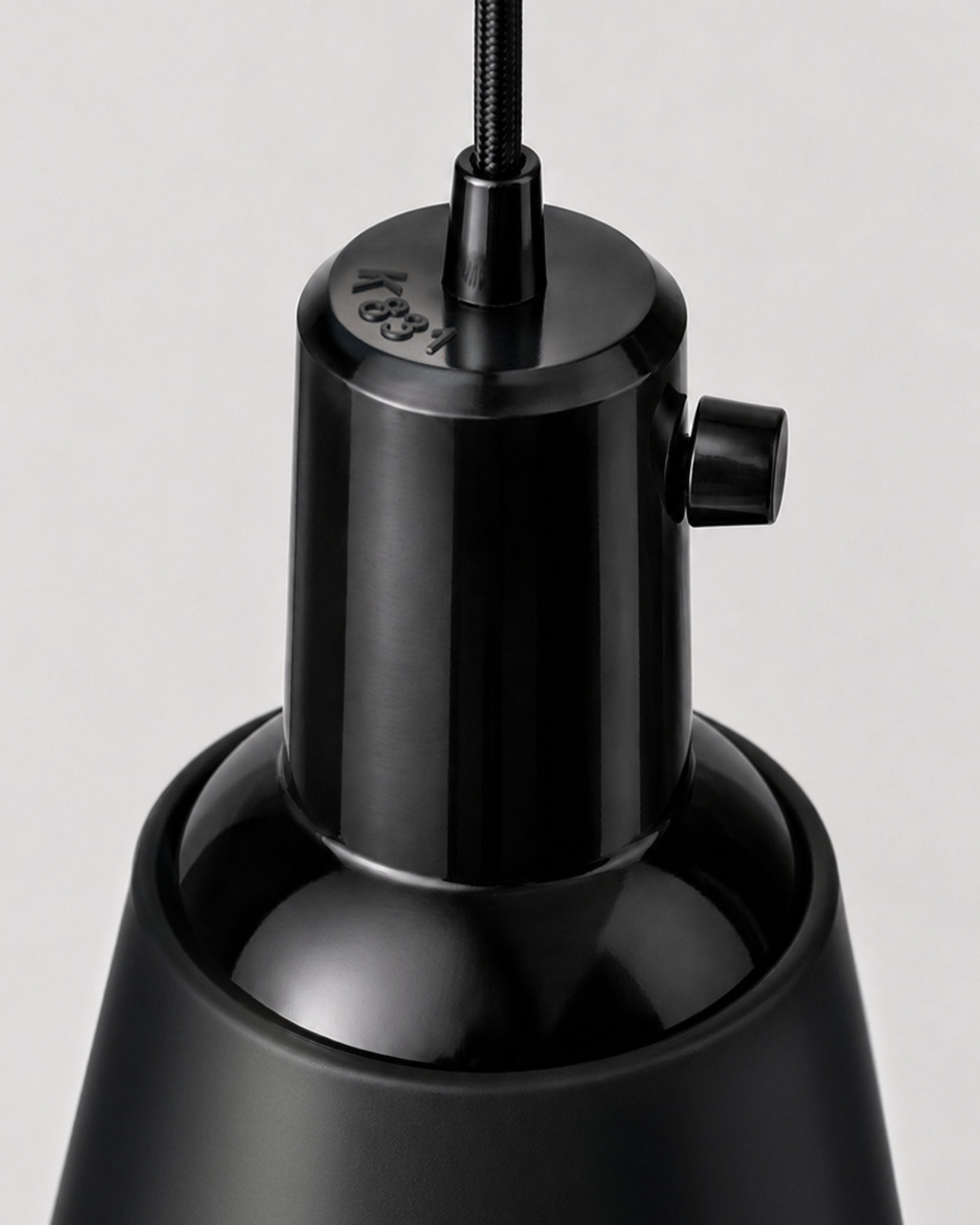 Detail of the Midgard K831 pendant lamp showing the black Bakelite dome and integrated rotary switch.
